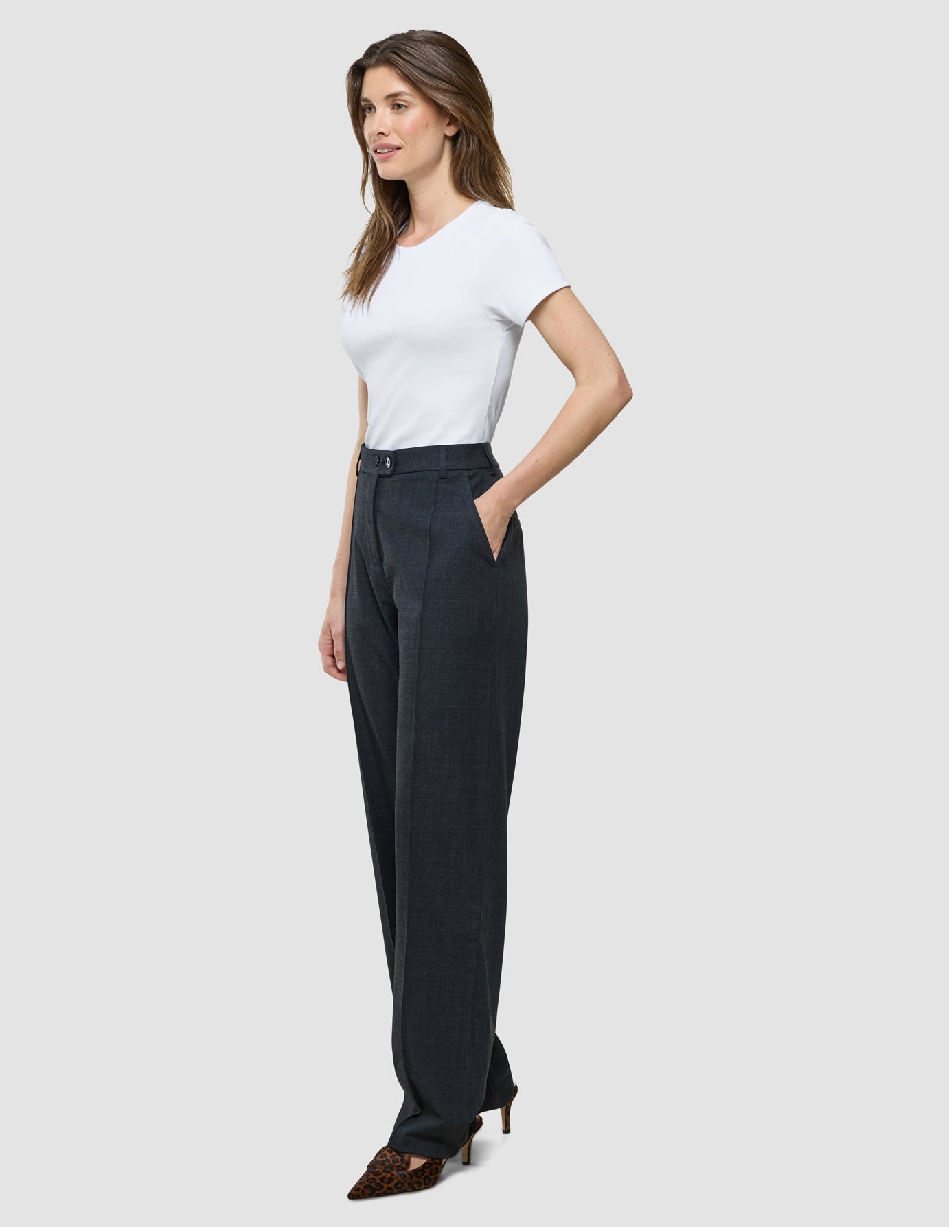 Eine Frau im Profil, die ein weißes T-Shirt und die „Women Nara Pants Straight Grey Flint“ trägt.